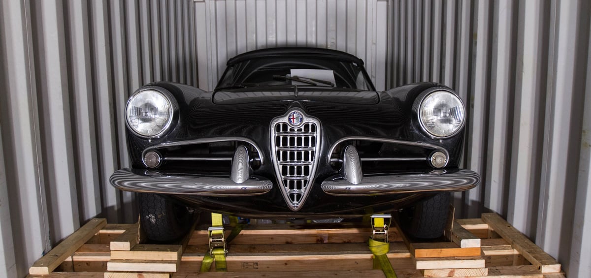 A classic Alfa Romeo strapped and braced inside a shipping container for ocean export
