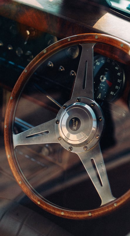 Detail of a classic Jaguar E-Type steering wheel and instrument panel