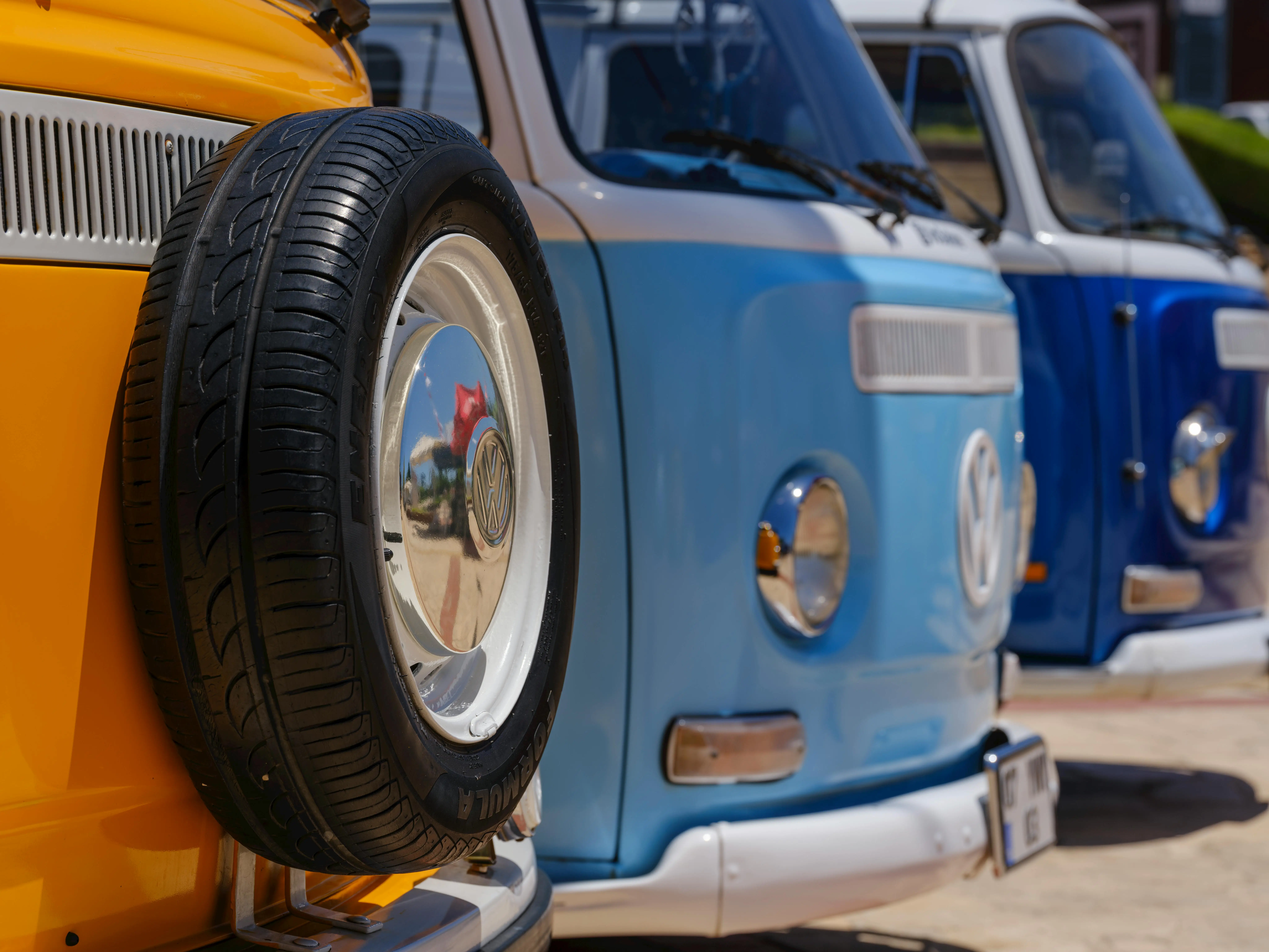 Colorful Vintage VW Vans in Sunlit Driveway