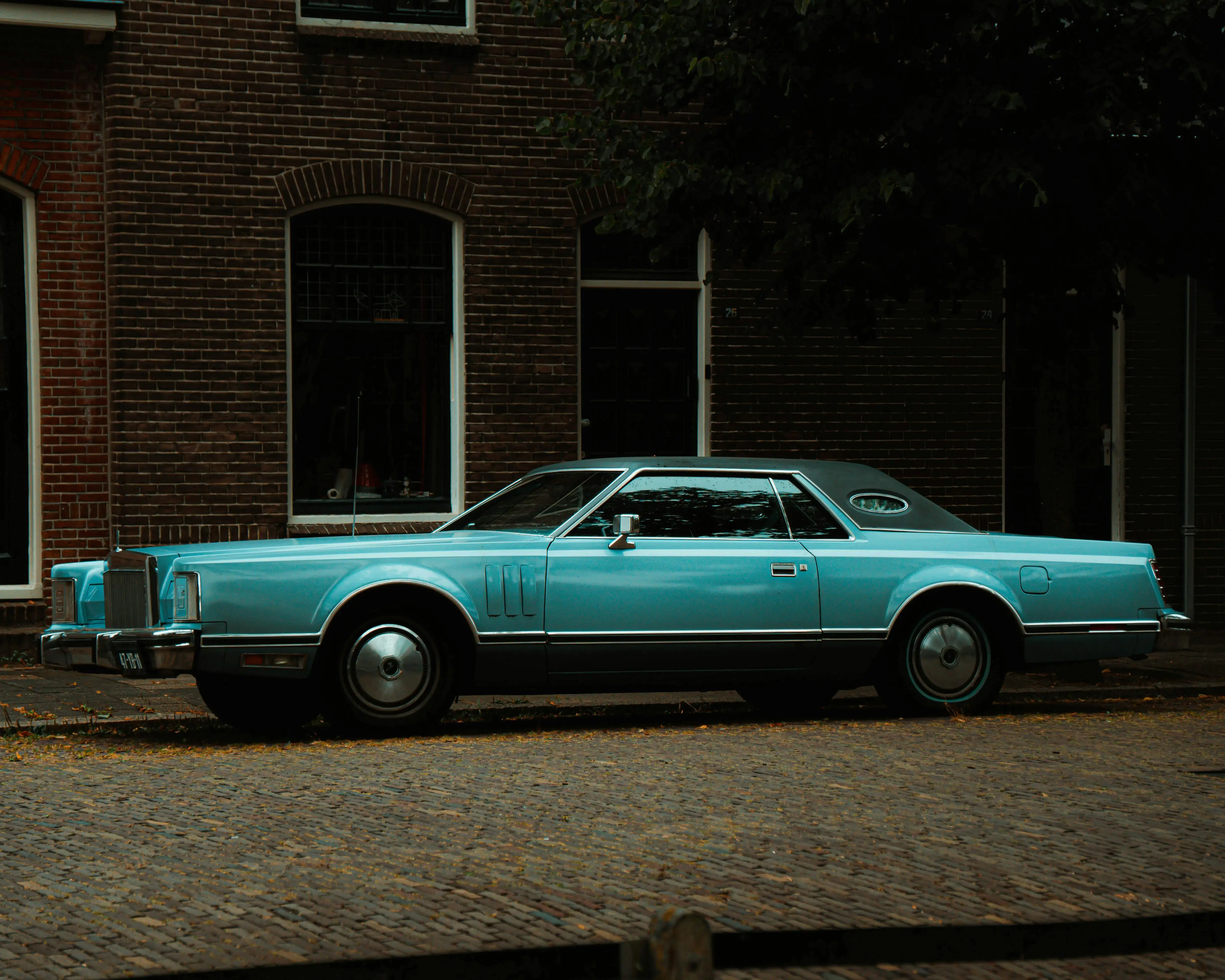 classic car parked in front of a house