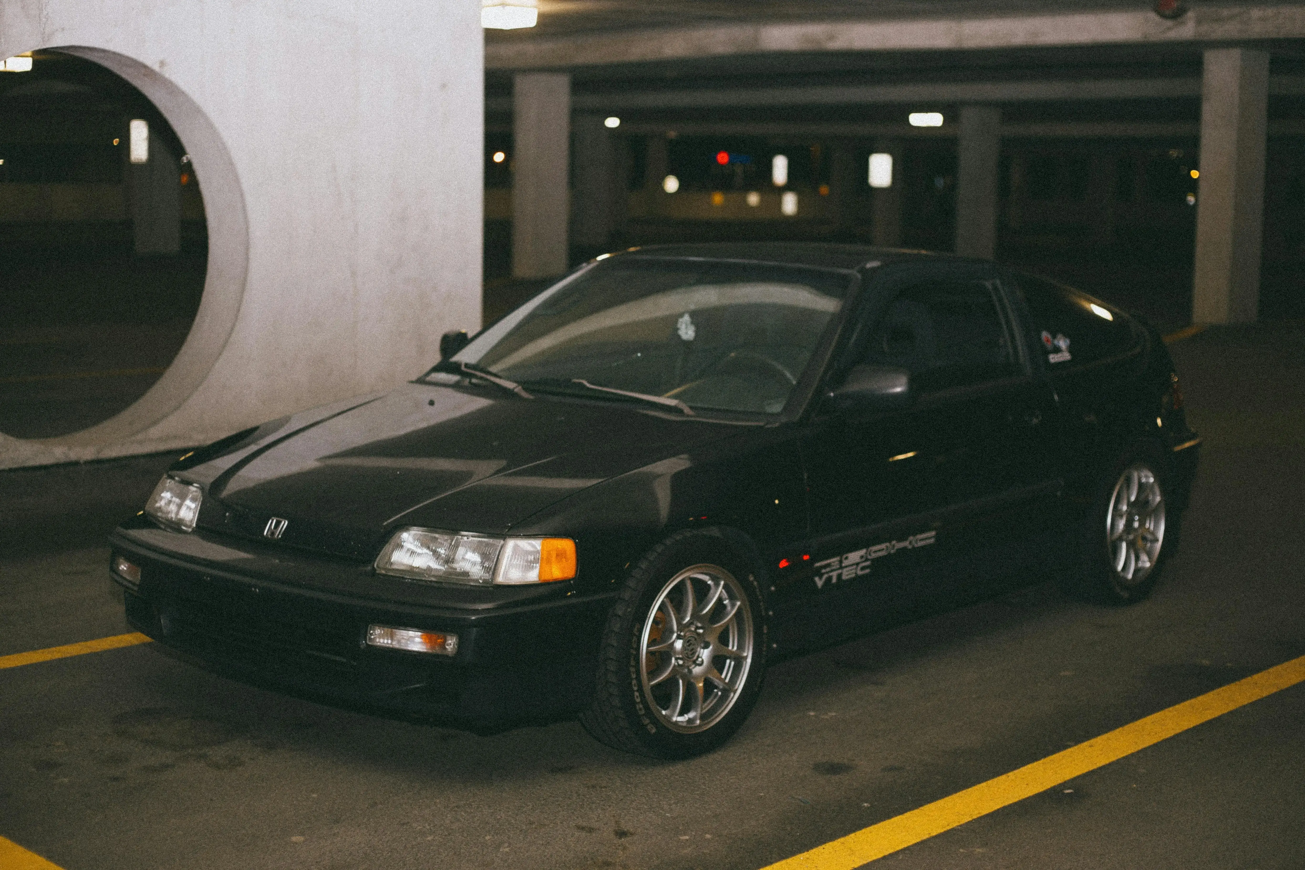 A Black Vintage Honda Civic CR-X Parked in a Parking Lot