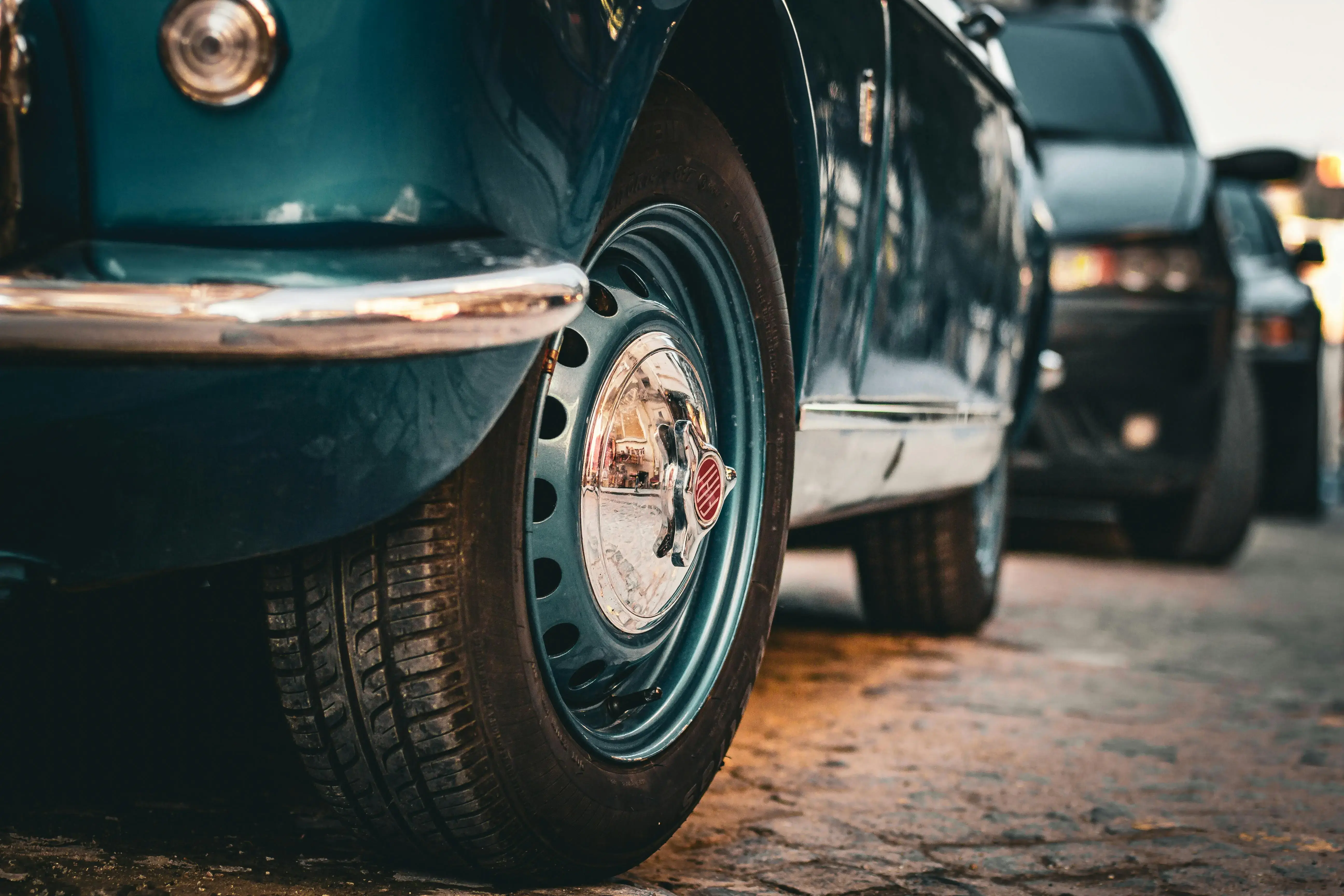 Close-up of a vintage teal car's wheel