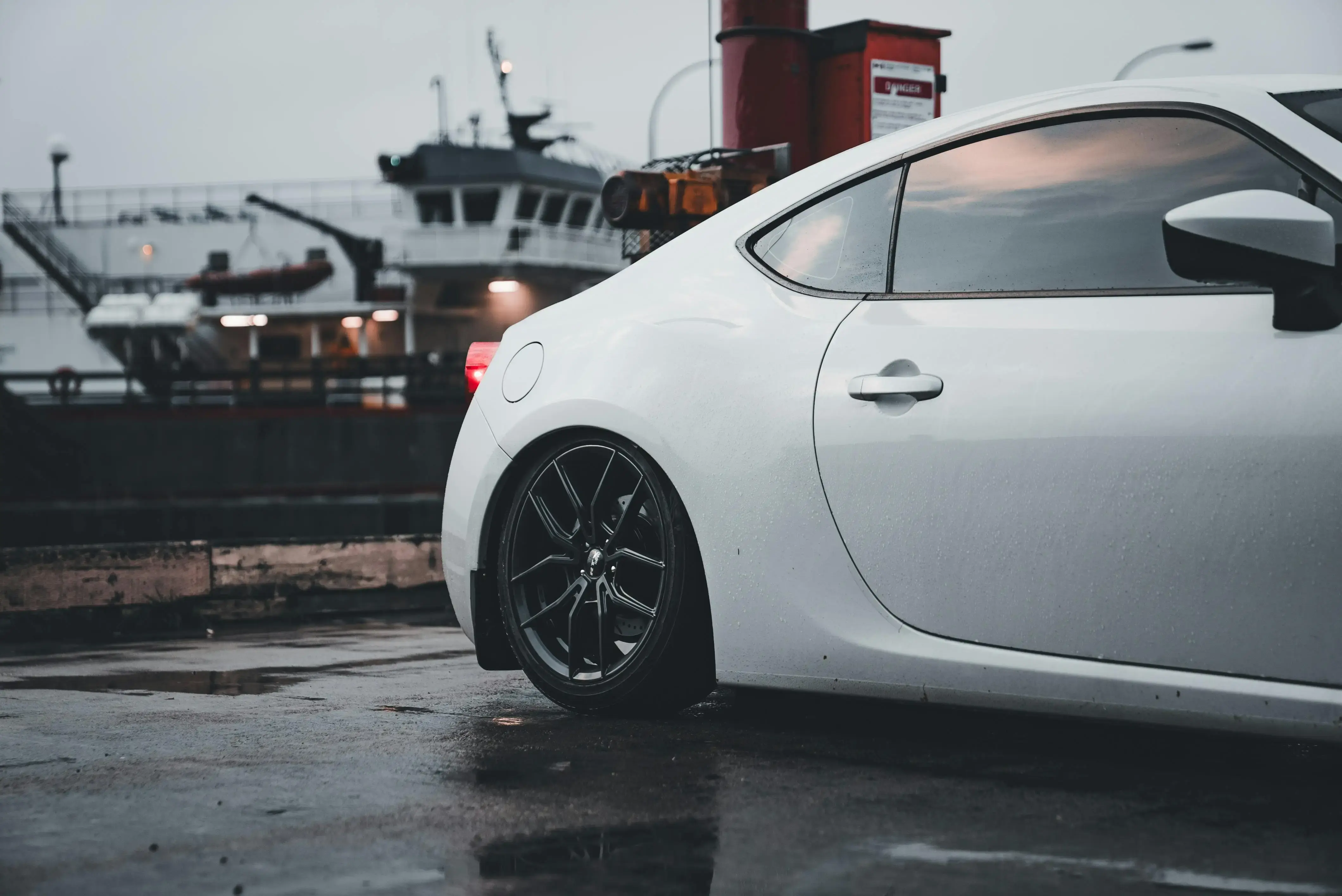 Sleek White Sports Car Parked by Waterfront Dock