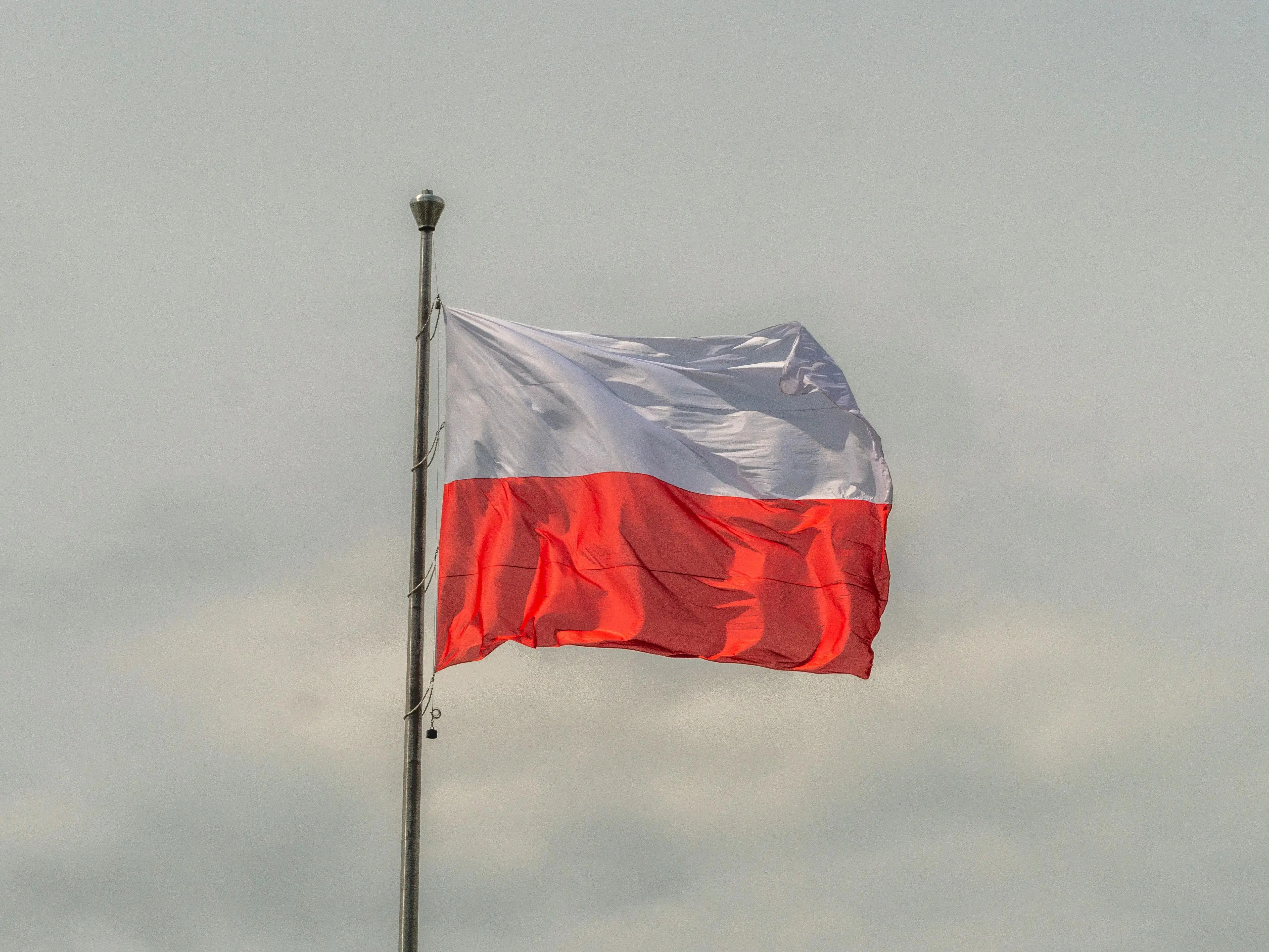 Polish National Flag Waving Against Cloudy Sky