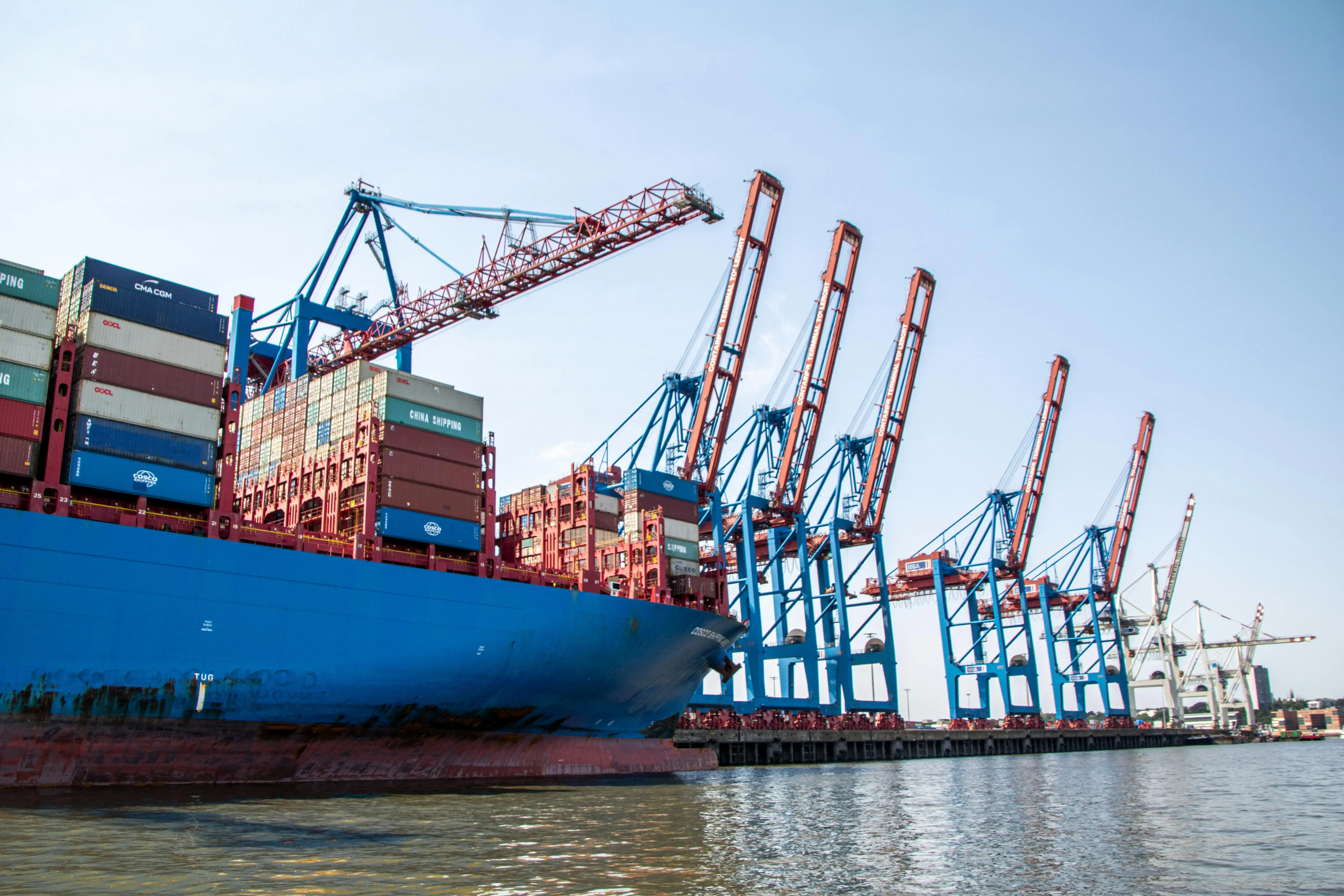 Construction Cranes and Container Ship in Harbor