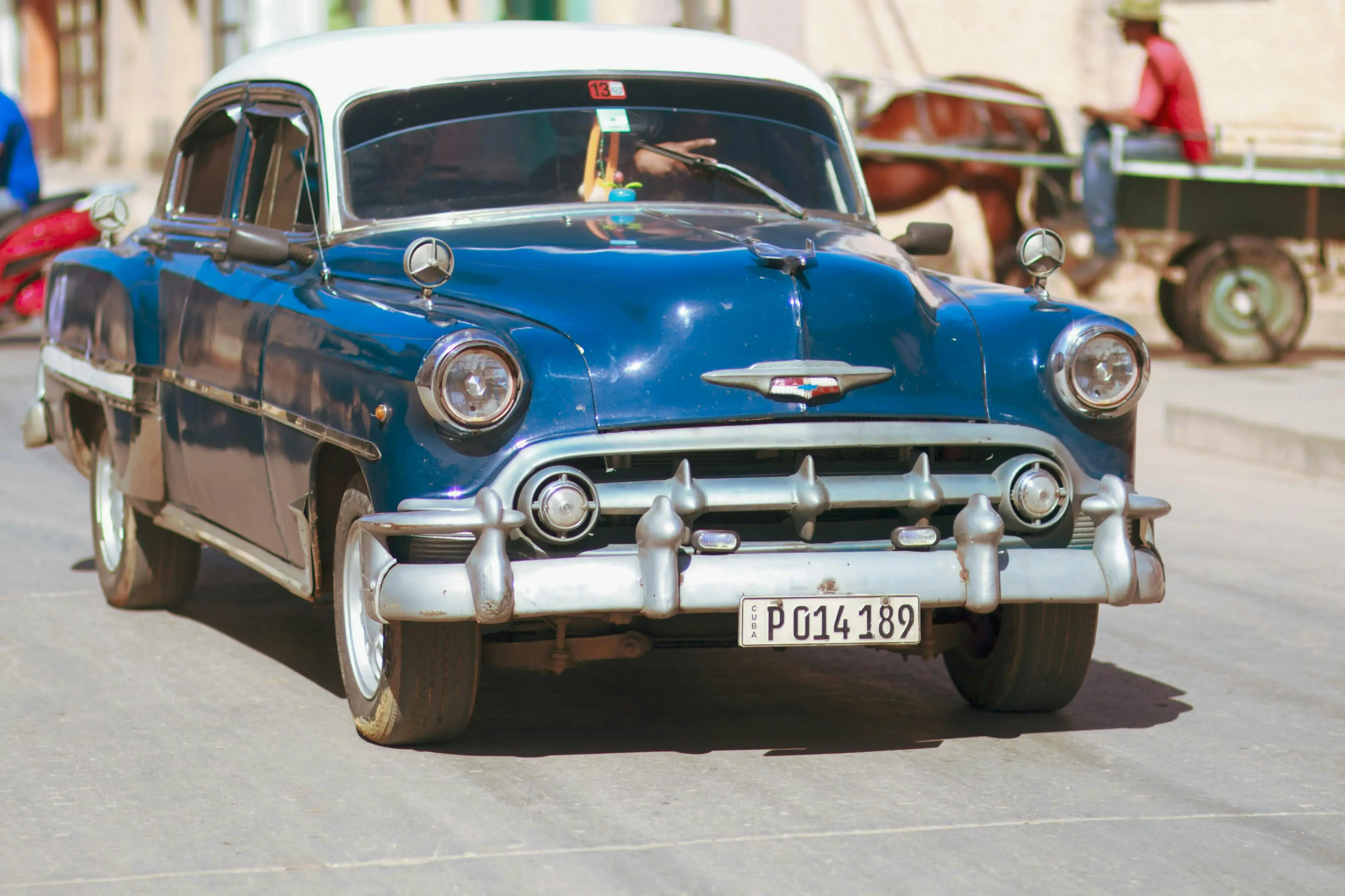 Blue and White Classic Car on the Road